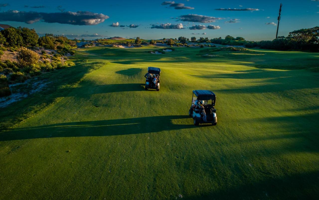 Pullman Magenta Shores Resort Entrance Exteriör bild Golf carts on the green
